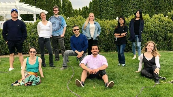 Lab group in Spring 2021 posing in grass, smiling.